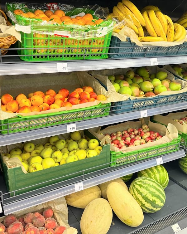 Kettle spout pouring boiling water into coffee grounds in pour-over mug.