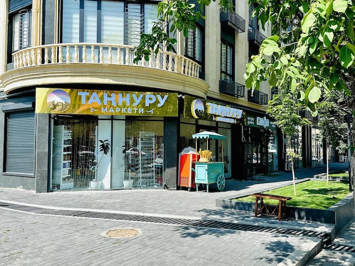 Black kettle with long pour spot and angled body on marble counter next to coffee mug and pour-over system.